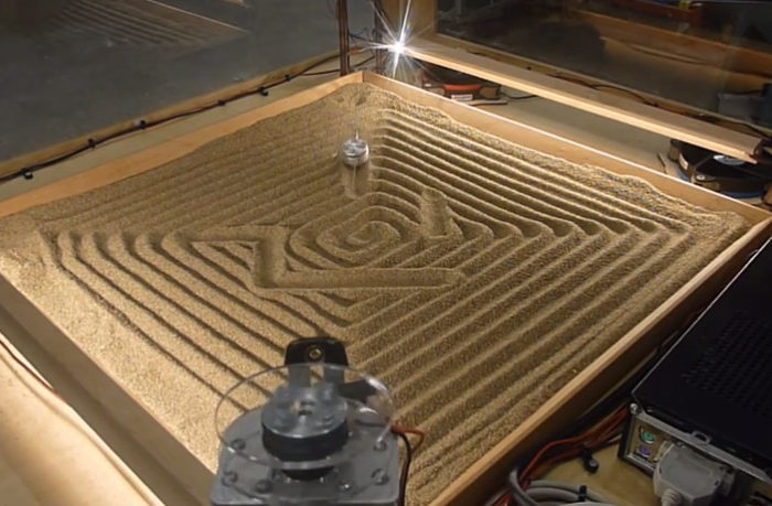 Une machine qui dessine dans le sable avec un système à 4 câbles